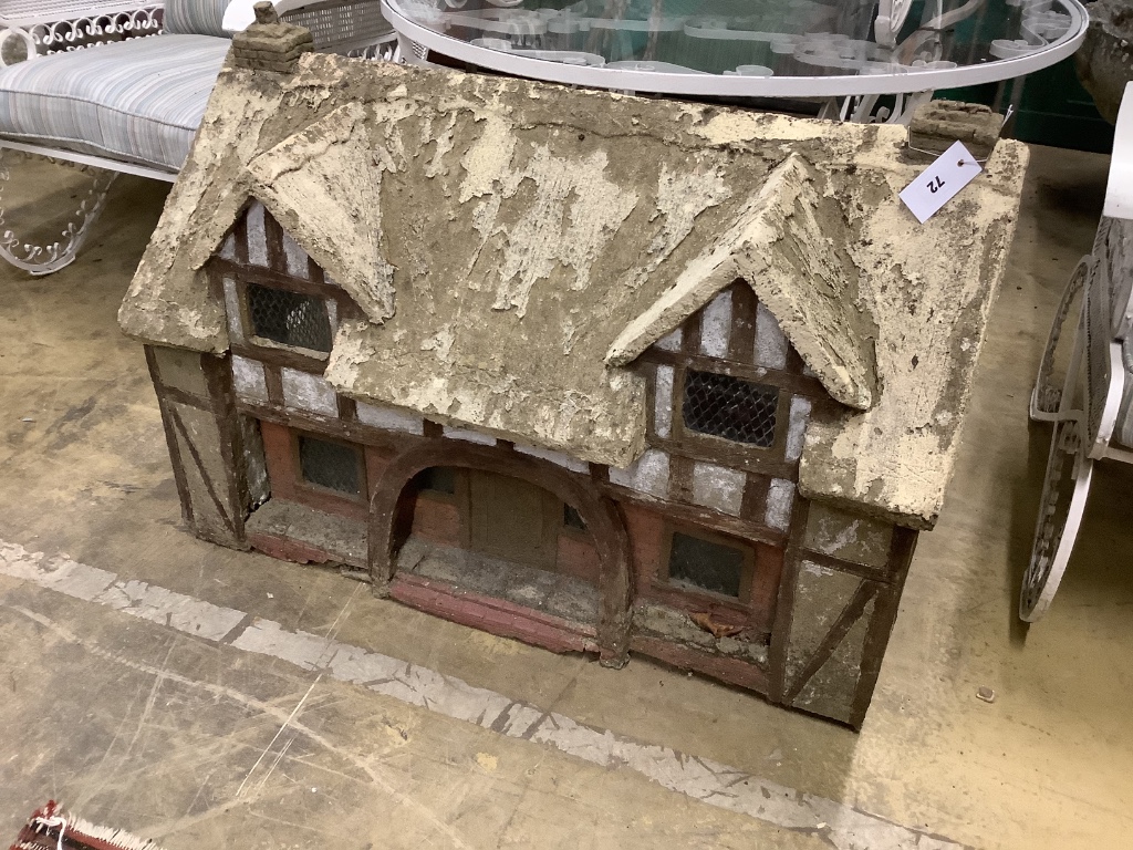 A reconstituted stone garden ornament, modelled as a Tudor cottage, width 86cm, depth 50cm, height 58cm